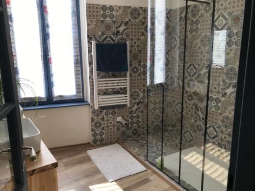 une douche avec une porte vitrée dans une salle de bain dans l'établissement Maison Corbieres, à Peyriac-de-Mer