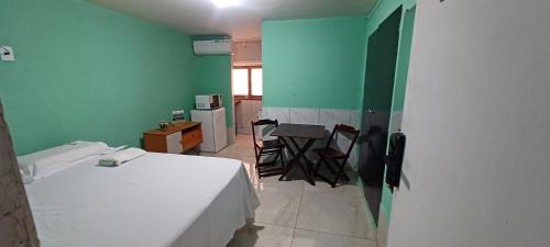 una habitación con una cama, una mesa y sillas en AP CENTRAL, en Campina Grande
