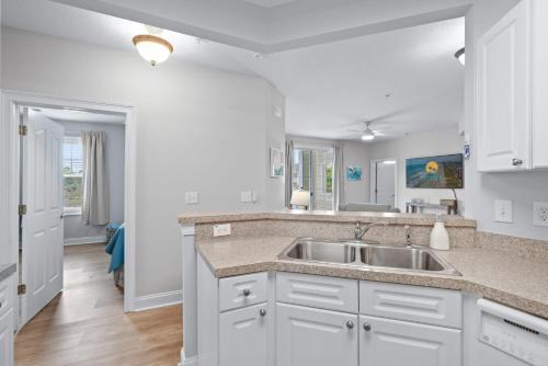 a kitchen with white cabinets and a sink at The Havens Barefoot Resort Unit 727 in North Myrtle Beach