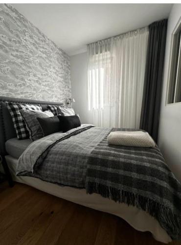 une chambre avec un lit avec une couverture et une fenêtre dans l'établissement appart avec piscine casino plein air et plage, à La Ciotat