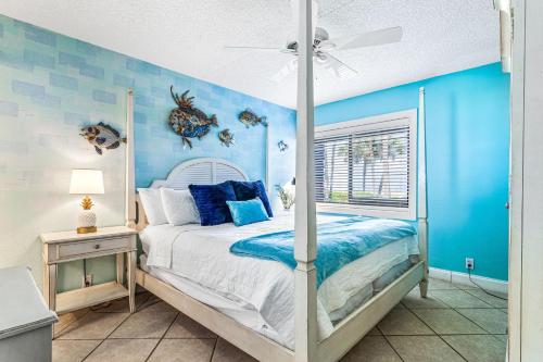 una camera da letto con un letto e una parete blu di Beachfront Aldea 3 a Clearwater Beach
