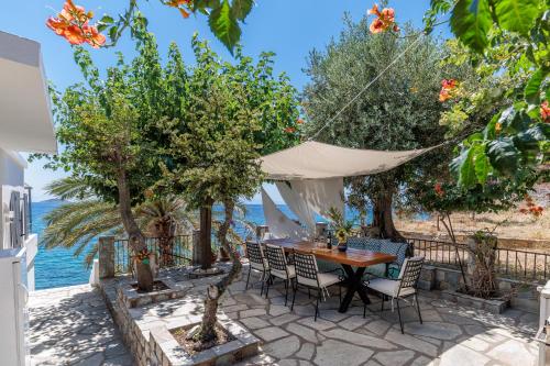 a patio with a table and chairs and the ocean at By the sea in Neo Klima