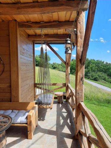 a porch of a wooden cabin with a hammock at Relax house Aurora in Jasenovica