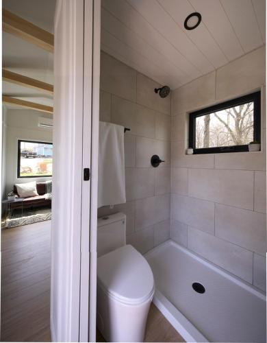 a bathroom with a toilet and a bath tub at The Endeavor Tiny Home! in Elizabethtown