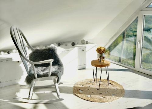 a white room with a chair and a table at Relax house Aurora in Jasenovica