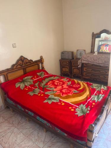 a bedroom with a bed with a red blanket at Waffa in Larache
