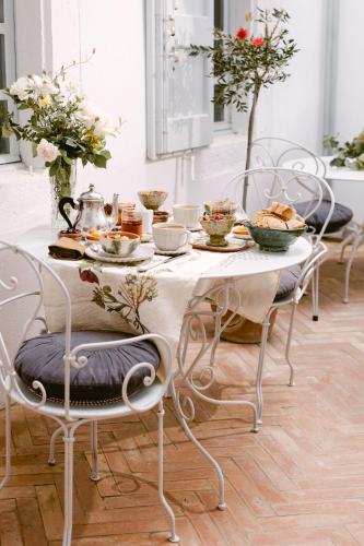 une table blanche avec des assiettes de nourriture dans l'établissement Château La Bruguière, à Tornac