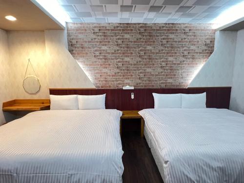 two beds sitting next to each other in a room at 微楓民宿 可加購晚餐酸白菜火鍋 in Renai