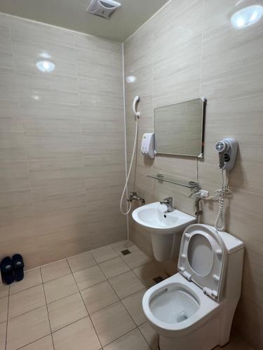a bathroom with a toilet and a sink and a mirror at 微楓民宿 可加購晚餐酸白菜火鍋 in Renai