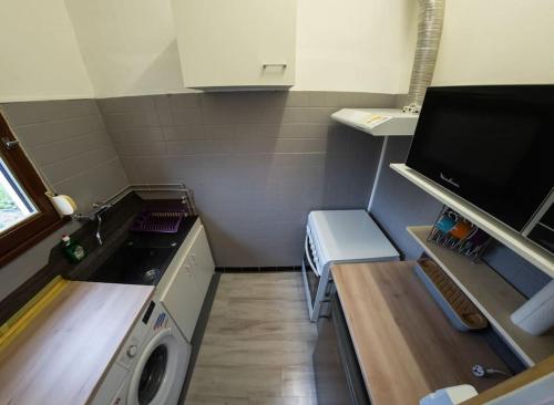 une petite cuisine avec une machine à laver et un évier dans l'établissement Duplex calme proche centre-ville, à Saint-Dizier