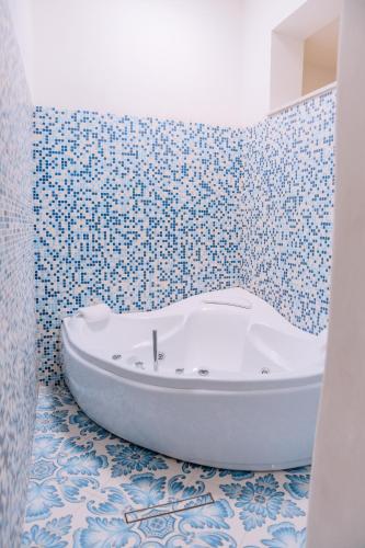 a bath tub in a bathroom with blue and white tiles at Omare Apartments in Sant'Angelo D'Ischia