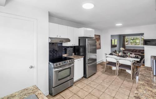 a kitchen with stainless steel appliances and a table at Cozy 3 Bedrooms Montreal in Montréal