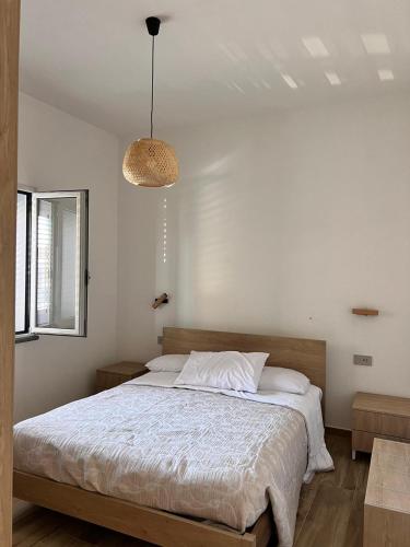 a bedroom with a bed and a pendant light at Casa dell arco in S'archittu Cuglieri