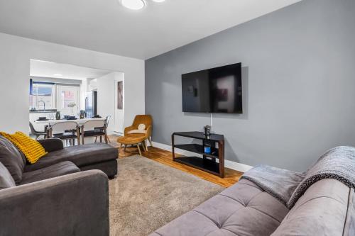 a living room with a couch and a dining room at Cozy 3 Bedrooms Montreal in Montréal