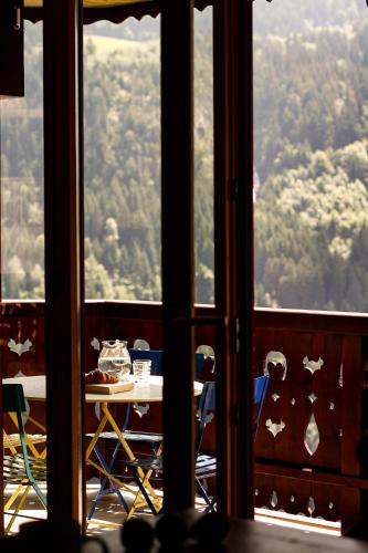 a room with a table and chairs looking out the window at Tesil 36 Duplex Overlooking The Village in Champéry