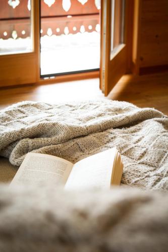 a book laying on top of a bed at Tesil 36 Duplex Overlooking The Village in Champéry