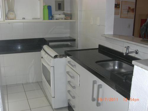 una cucina bianca con lavandino e lavastoviglie di Apartamento na Praia do Futuro a Fortaleza