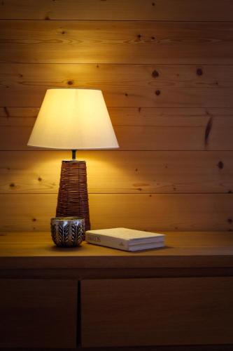a lamp sitting on top of a table with a book at Tesil 36 Duplex Overlooking The Village in Champéry