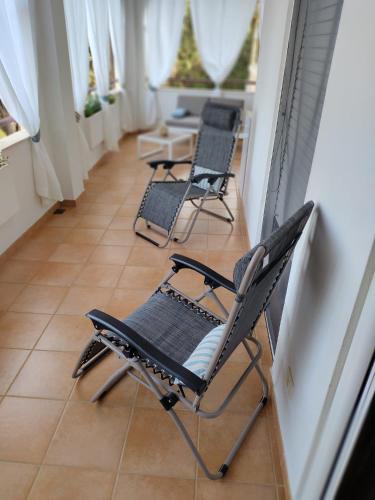a row of chairs sitting on a porch at Quiet Home in Pula