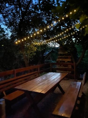 a wooden picnic table under a string of lights at Naomi vendégház in Sovata