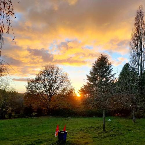 a sunset in a field with the sun setting behind trees at Manoir La Tasserie in Saint-Philbert-des-Champs