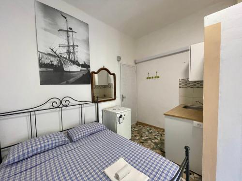 Un pequeño dormitorio con una cama y una cocina. en Apartments Viareggio, en Viareggio