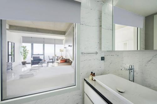 a white bathroom with a sink and a mirror at Gorgeous Bright Studio Parking Poolviews! #135 in Istanbul