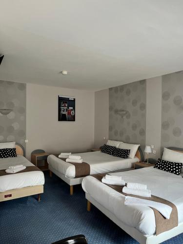 a hotel room with three beds and a couch at Hotel du Nord - Ville-Haute in Saint-Flour
