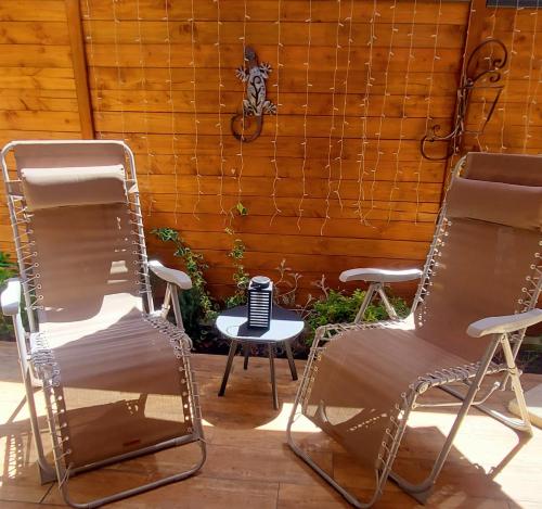 two chairs and a table in front of a fence at Spacieuse Dépendance Duplex 50 M2 Classé 3 étoiles in Gréoux-les-Bains