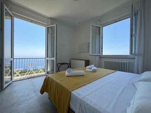a bedroom with a bed with a view of the ocean at Ca' dii Bürsa - HOMY 5 TERRE in Volastra