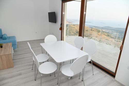 a white table and chairs in a room with a large window at Villa Panorama - autumn luxury villa - heated pool and jacuzzi in Ivanica