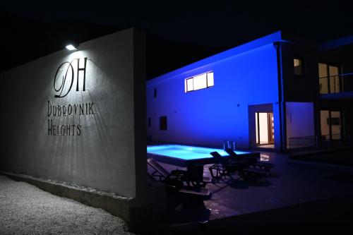 a building with a table and chairs in the dark at Villa Panorama - autumn luxury villa - heated pool and jacuzzi in Ivanica