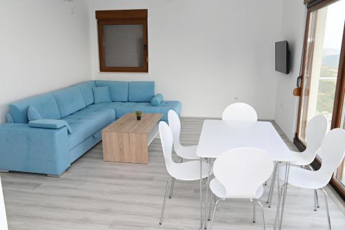 a living room with a blue couch and a table and chairs at Villa Panorama - autumn luxury villa - heated pool and jacuzzi in Ivanica