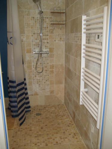 une salle de bain avec une douche avec un rideau de douche dans l'établissement Maison avec piscine privée, à Nîmes