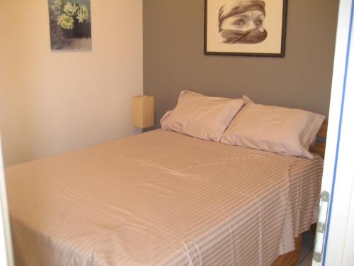 Cette petite chambre comprend un lit avec des draps blancs. dans l'établissement Maison avec piscine privée, à Nîmes