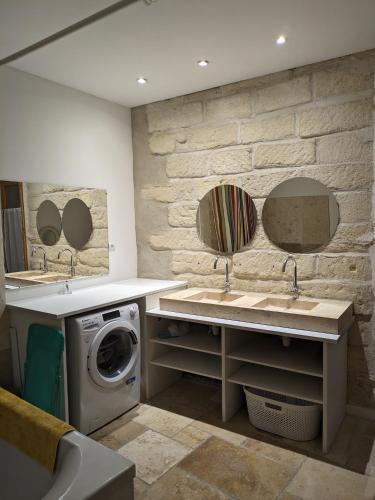 - une buanderie avec deux lavabos et un lave-linge dans l'établissement Charmant 3 pièces à Sommières, à Sommières