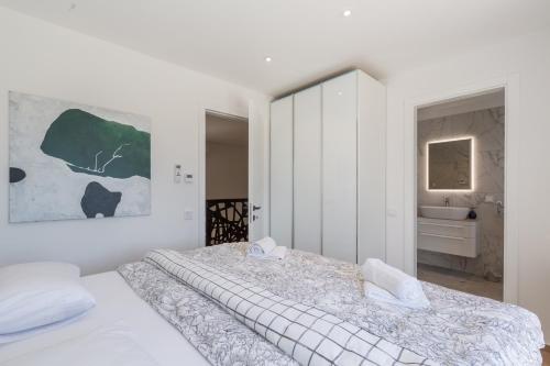 a white bedroom with a large bed and a sink at Villa Mirela Lux in Šišan