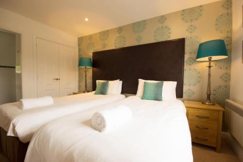a bedroom with two beds with white sheets and green pillows at Farley in Matlock