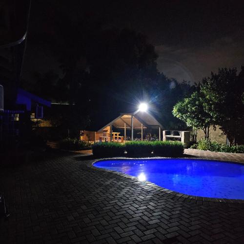 a night time picture of a blue swimming pool at ZUCH Accommodation at Pafuri Self Catering - Guest Suite in Polokwane