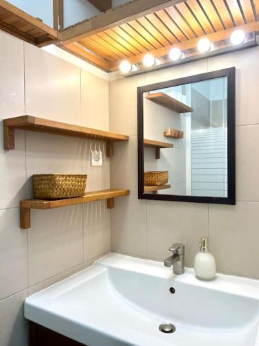 une salle de bain avec un lavabo et un miroir dans l'établissement Woody - Parc Salengro - Balcon, à Clichy