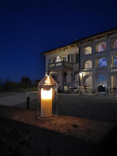 a candle in a glass jar in front of a building at Theresa sulla Collina in Passerano 