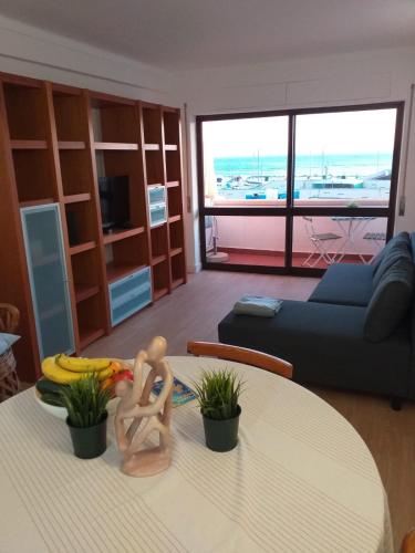 a living room with a table with two people on it at Lisbon Beach Flat- Costa Caparica in Costa da Caparica