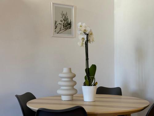 a wooden table with a vase with a flower on it at Il Vicoletto Marino in Marino