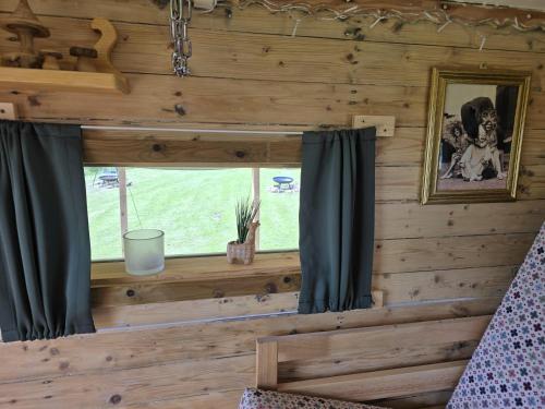 a window in a log cabin with black curtains at Restored circus wagon in Saltburn-by-the-Sea