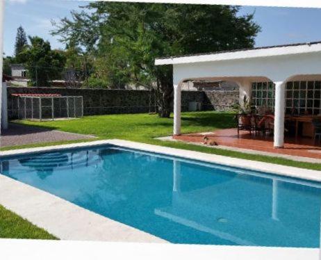 a large blue swimming pool in a yard at Bungalows Iris in Chiconcuac