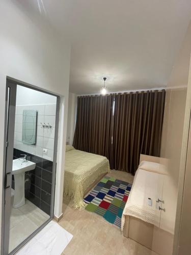a bedroom with a bed and a sink and a mirror at "Frogs House" Hotel & Restorant Slow Food in Lushnjë