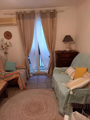 un salon avec un canapé et une fenêtre dans l'établissement Argeles Maison de Caractere, à Argelès-sur-Mer