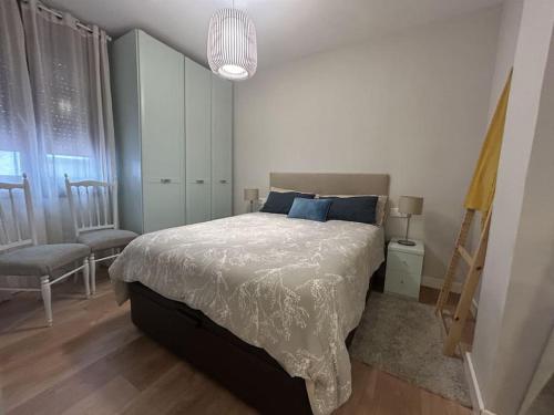 a bedroom with a bed and a chair and a window at Loft in Uribarri in Bilbao