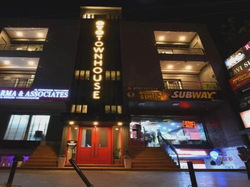 a building with a neon sign on the side of it at Townhouse Rudra Inn Near Chhatarpur Metro Station in New Delhi