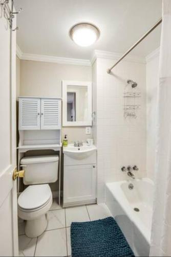 a white bathroom with a toilet and a sink at Southern Charm Cottage in Hickory